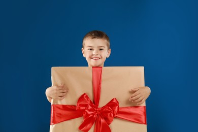 Cute little boy dressed as gift box on blue background. Christmas suit Image of Cute little boy dressed as gift box on blue background. Christmas suit