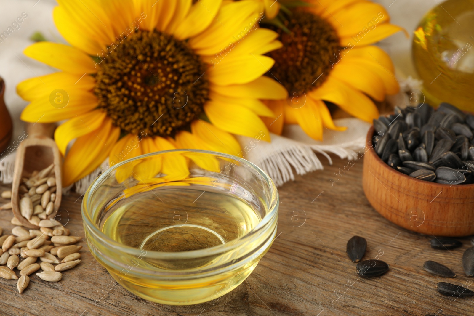 Sunflower oil and seeds on wooden table, closeup Photo of Sunflower oil and seeds on wooden table, closeup