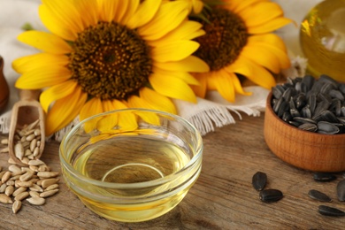 Sunflower oil and seeds on wooden table, closeup Photo of Sunflower oil and seeds on wooden table, closeup