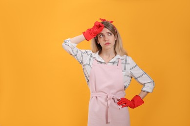 Photo of Young housewife in gloves on yellow background. Space for text