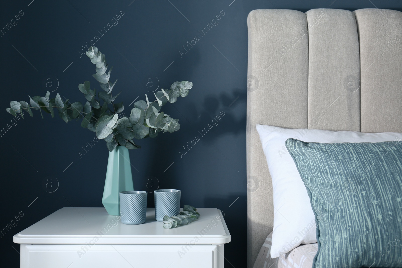 Beautiful eucalyptus branches and candles on nightstand in bedroom. Interior element Photo of Beautiful eucalyptus branches and candles on nightstand in bedroom. Interior element