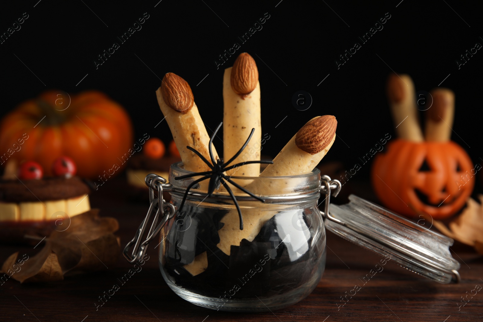 Delicious desserts decorated as monster fingers on wooden table. Halloween treat Photo of Delicious desserts decorated as monster fingers on wooden table. Halloween treat