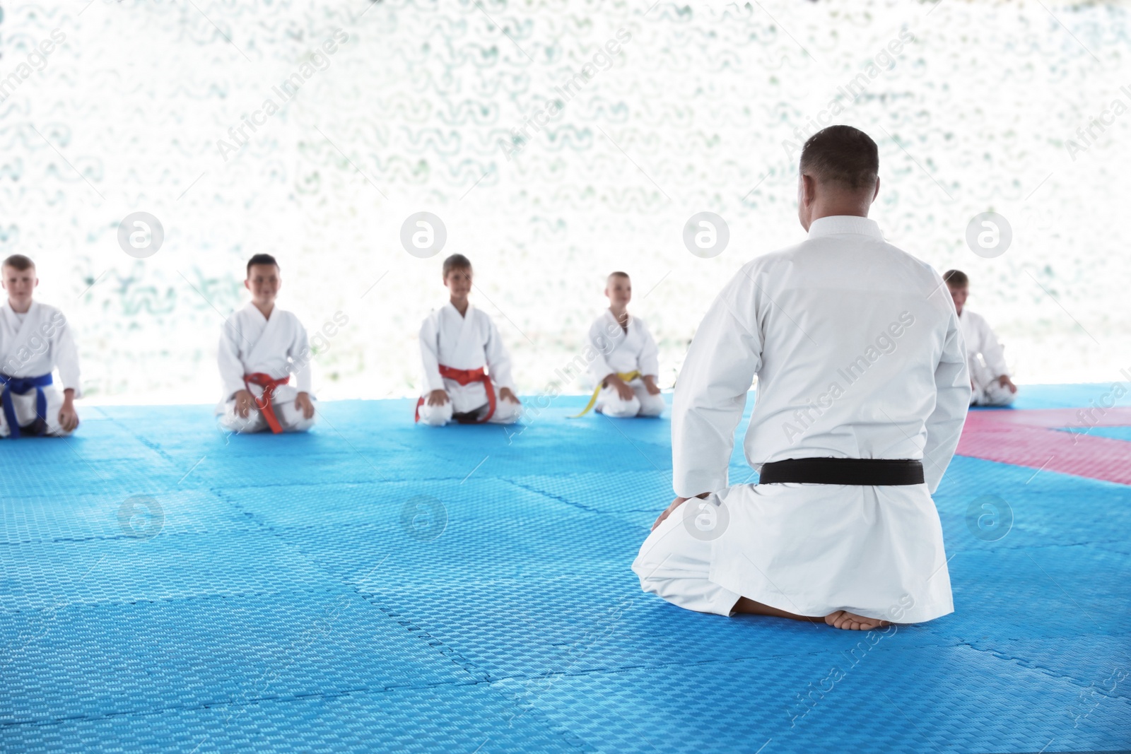 OCHAKIV, UKRAINE - JULY 09, 2020: Coach and children in kimono sitting on tatami in pavilion. Summer camp "Sportium" Photo of OCHAKIV, UKRAINE - JULY 09, 2020: Coach and children in kimono sitting on tatami in pavilion. Summer camp "Sportium"