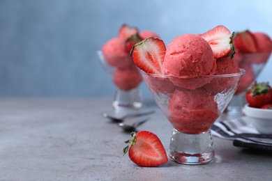 Delicious strawberry ice cream served on grey table. Space for text Photo of Delicious strawberry ice cream served on grey table. Space for text