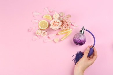 Woman with perfume. Fragrance composition, flowers and lemon on pink background, top view Photo of Woman with perfume. Fragrance composition, flowers and lemon on pink background, top view