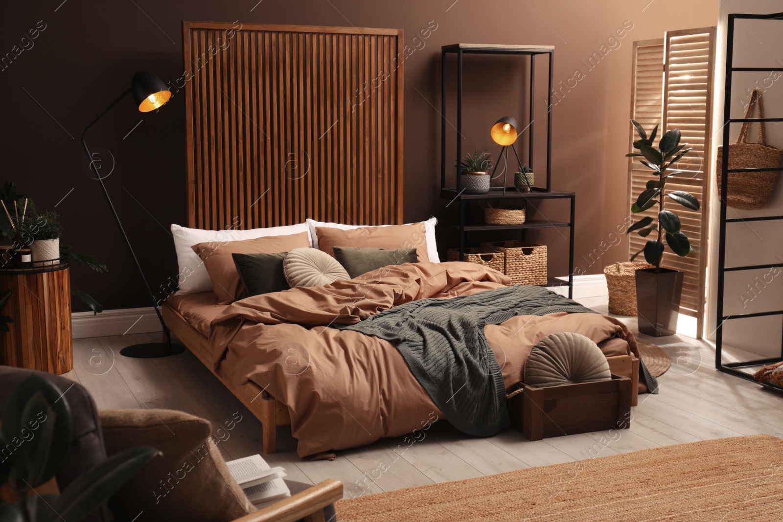 Stylish room interior with large bed near brown wall Photo of Stylish room interior with large bed near brown wall