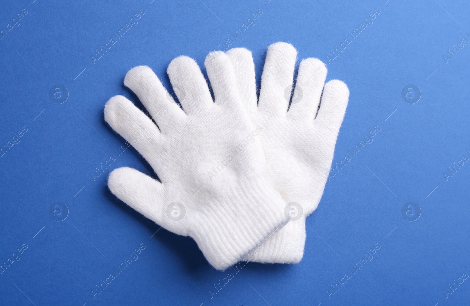 Pair of stylish woolen gloves on blue background, flat lay Photo of Pair of stylish woolen gloves on blue background, flat lay