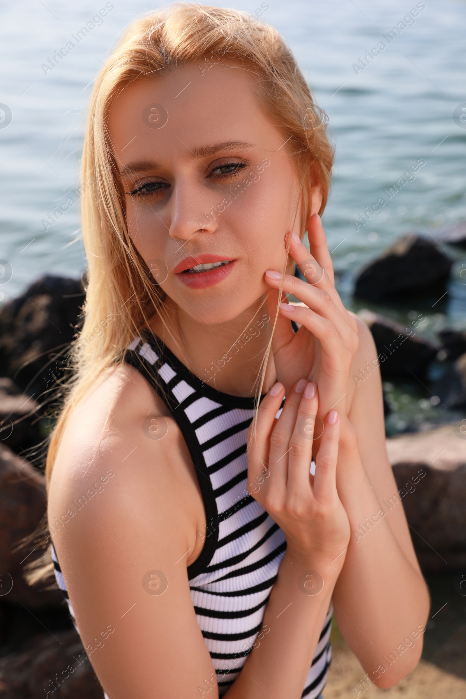 Beautiful young woman near sea on sunny day in summer Photo of Beautiful young woman near sea on sunny day in summer