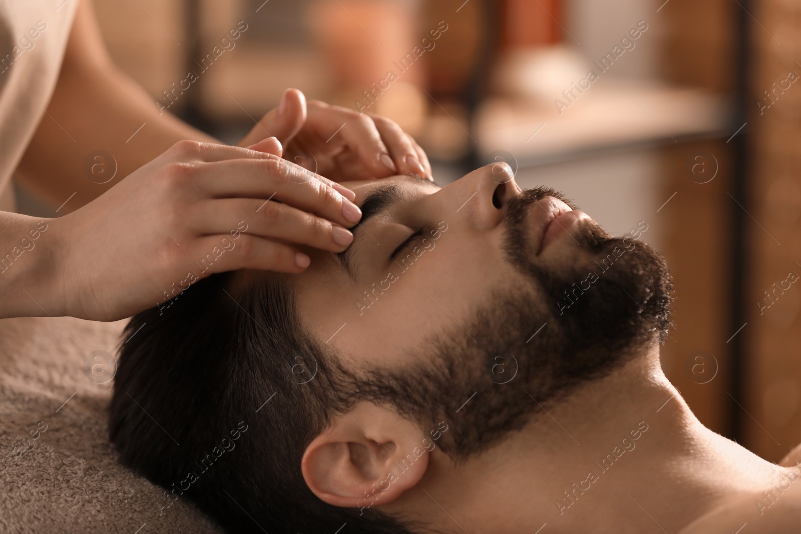 Young man receiving facial massage in beauty salon, closeup Photo of Young man receiving facial massage in beauty salon, closeup