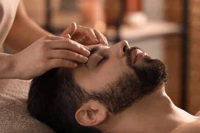Young man receiving facial massage in beauty salon, closeup Photo of Young man receiving facial massage in beauty salon, closeup