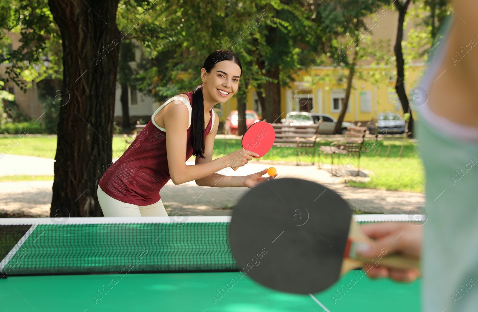 Young women playing ping pong in park Photo of Young women playing ping pong in park
