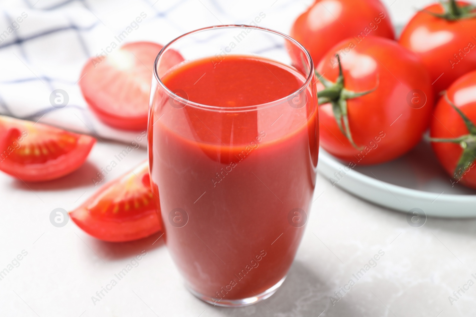 Delicious fresh tomato juice on light grey marble table table, closeup Photo of Delicious fresh tomato juice on light grey marble table table, closeup