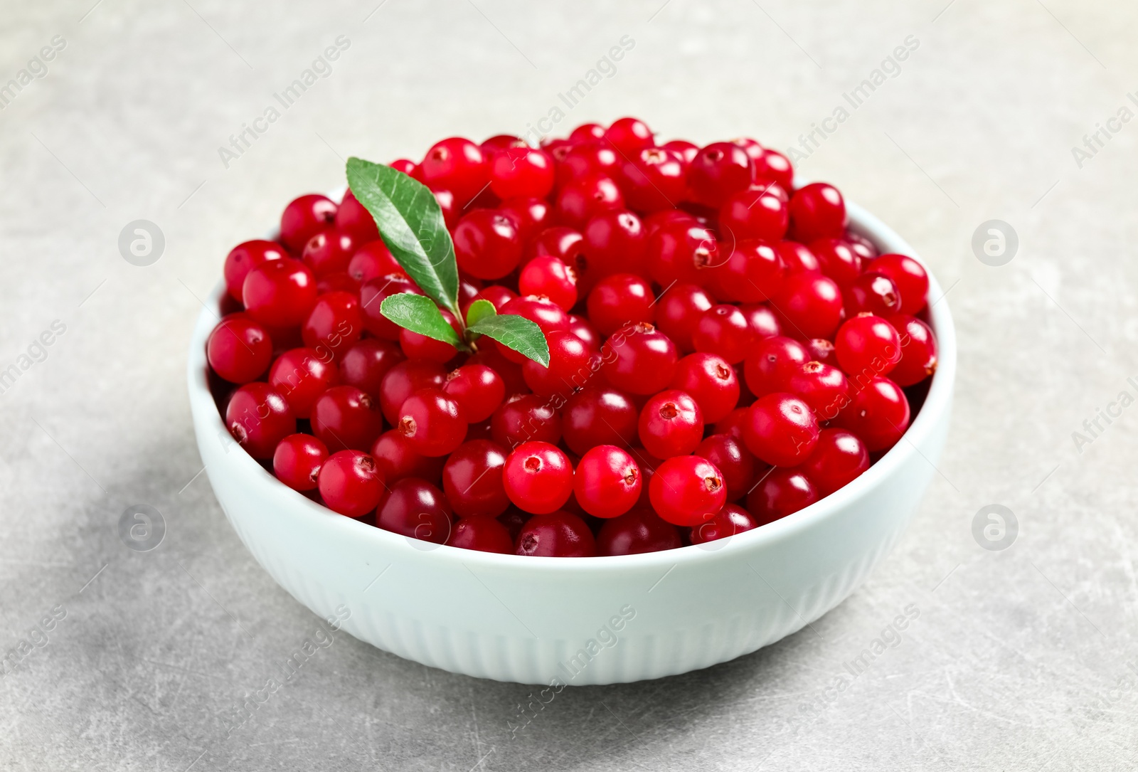Tasty ripe cranberries on grey table, closeup Photo of Tasty ripe cranberries on grey table, closeup
