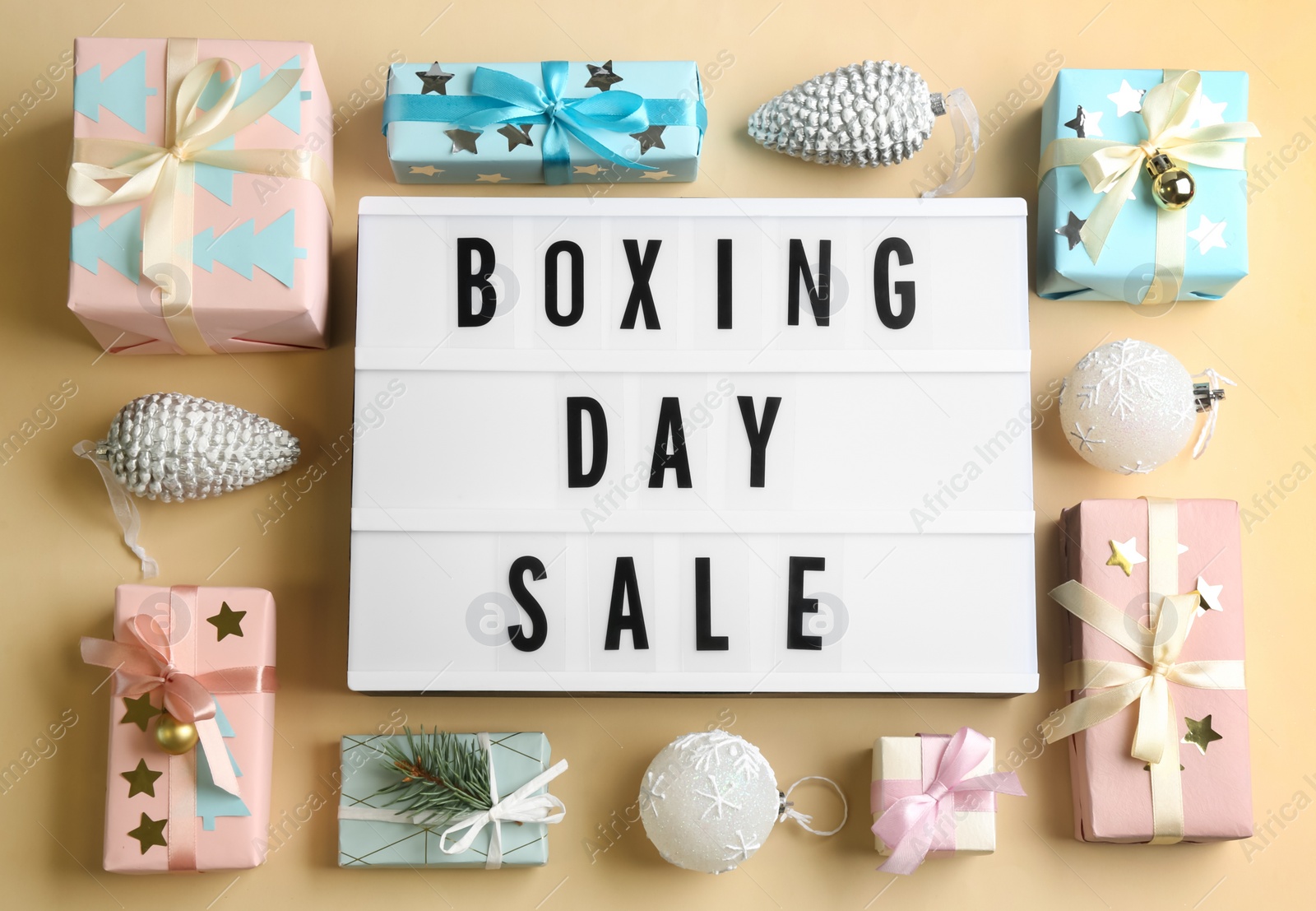 Lightbox with phrase BOXING DAY SALE and Christmas decorations on beige background, flat lay Photo of Lightbox with phrase BOXING DAY SALE and Christmas decorations on beige background, flat lay