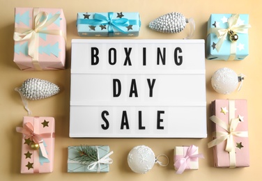 Lightbox with phrase BOXING DAY SALE and Christmas decorations on beige background, flat lay Photo of Lightbox with phrase BOXING DAY SALE and Christmas decorations on beige background, flat lay