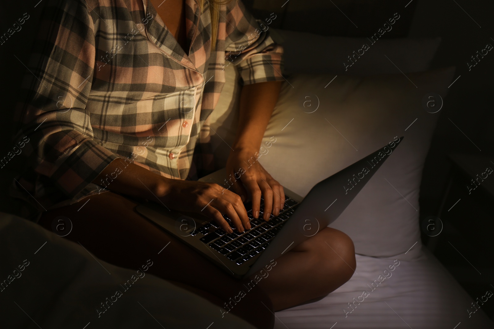 Woman using laptop in bed at night, closeup. Sleeping disorder problem Photo of Woman using laptop in bed at night, closeup. Sleeping disorder problem