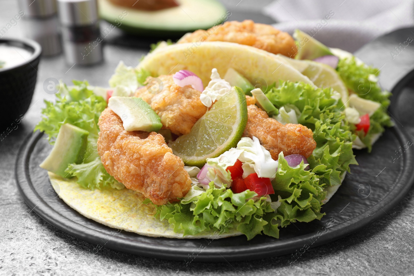Delicious fish tacos served on grey table, closeup Photo of Delicious fish tacos served on grey table, closeup
