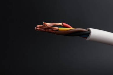 Cable with electrical wires on black background, closeup Photo of Cable with electrical wires on black background, closeup