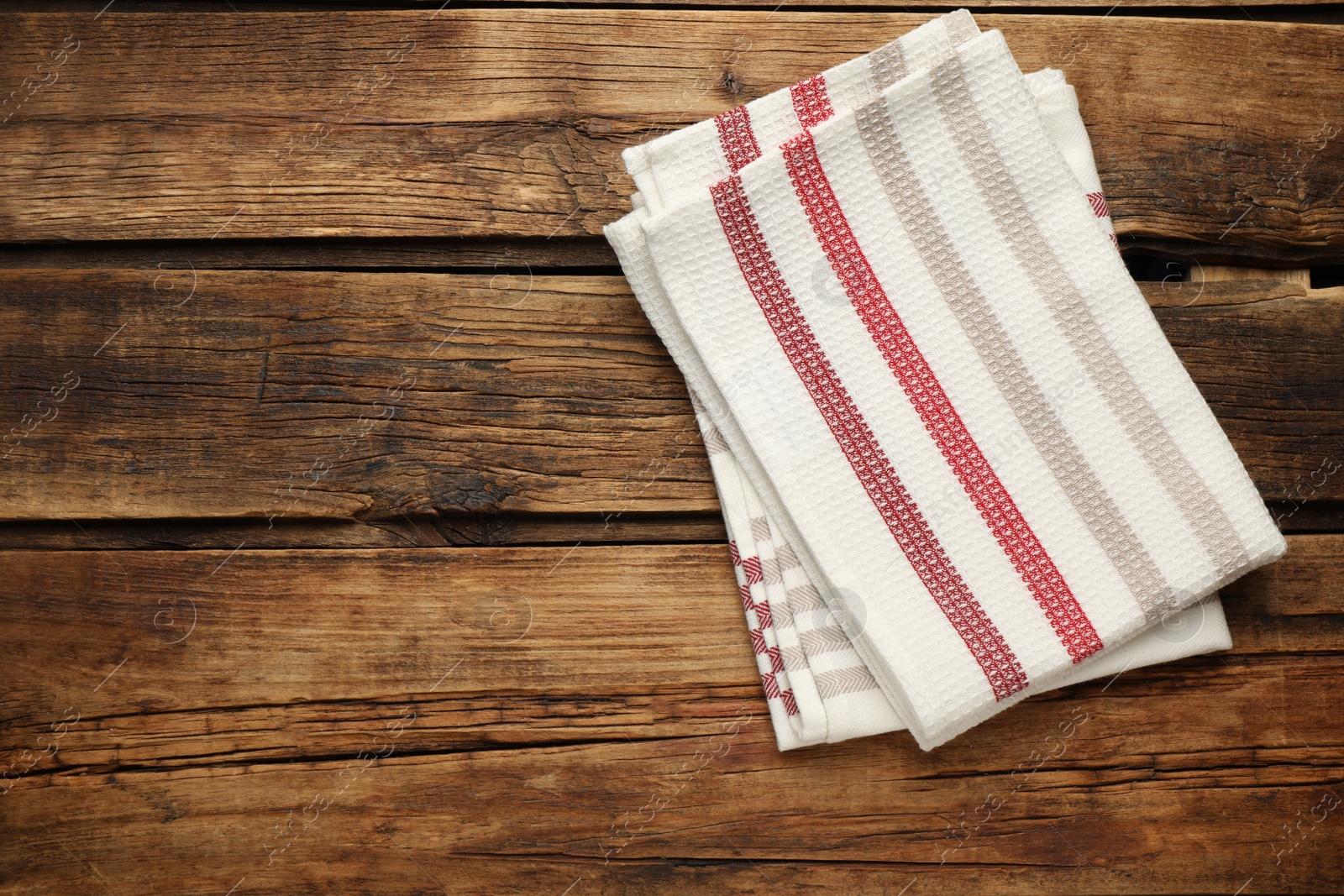 Striped kitchen towels on wooden table, top view. Space for text Photo of Striped kitchen towels on wooden table, top view. Space for text