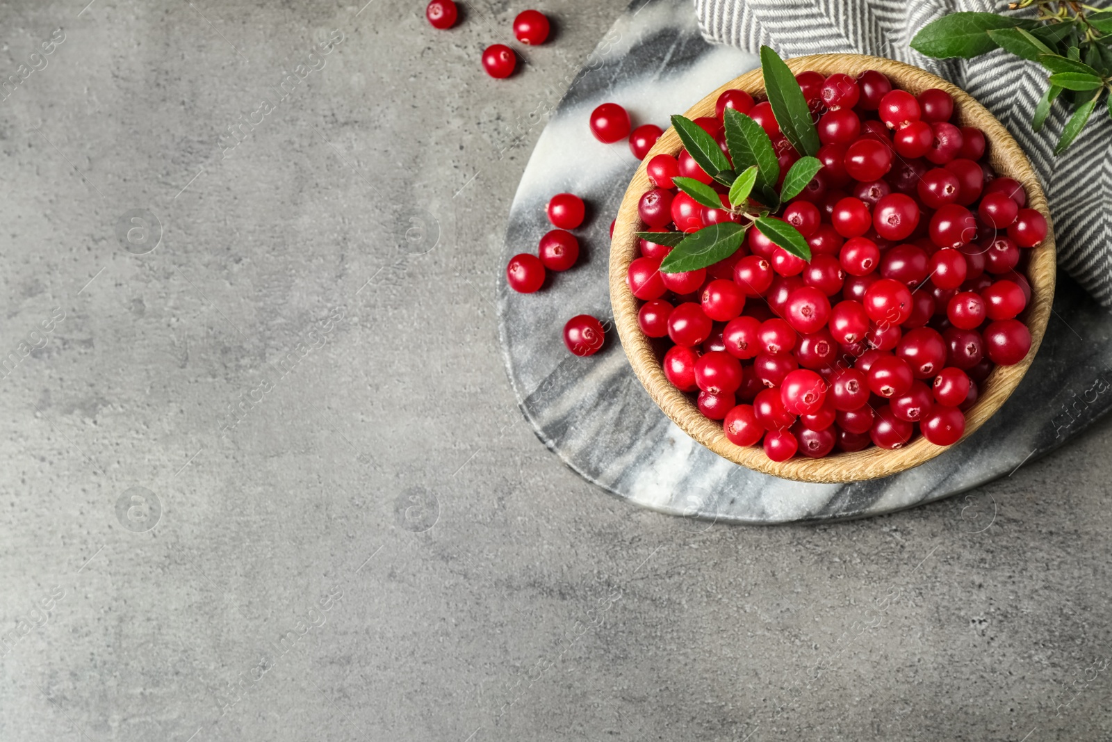 Tasty ripe cranberries on grey table, flat lay. Space for text Photo of Tasty ripe cranberries on grey table, flat lay. Space for text
