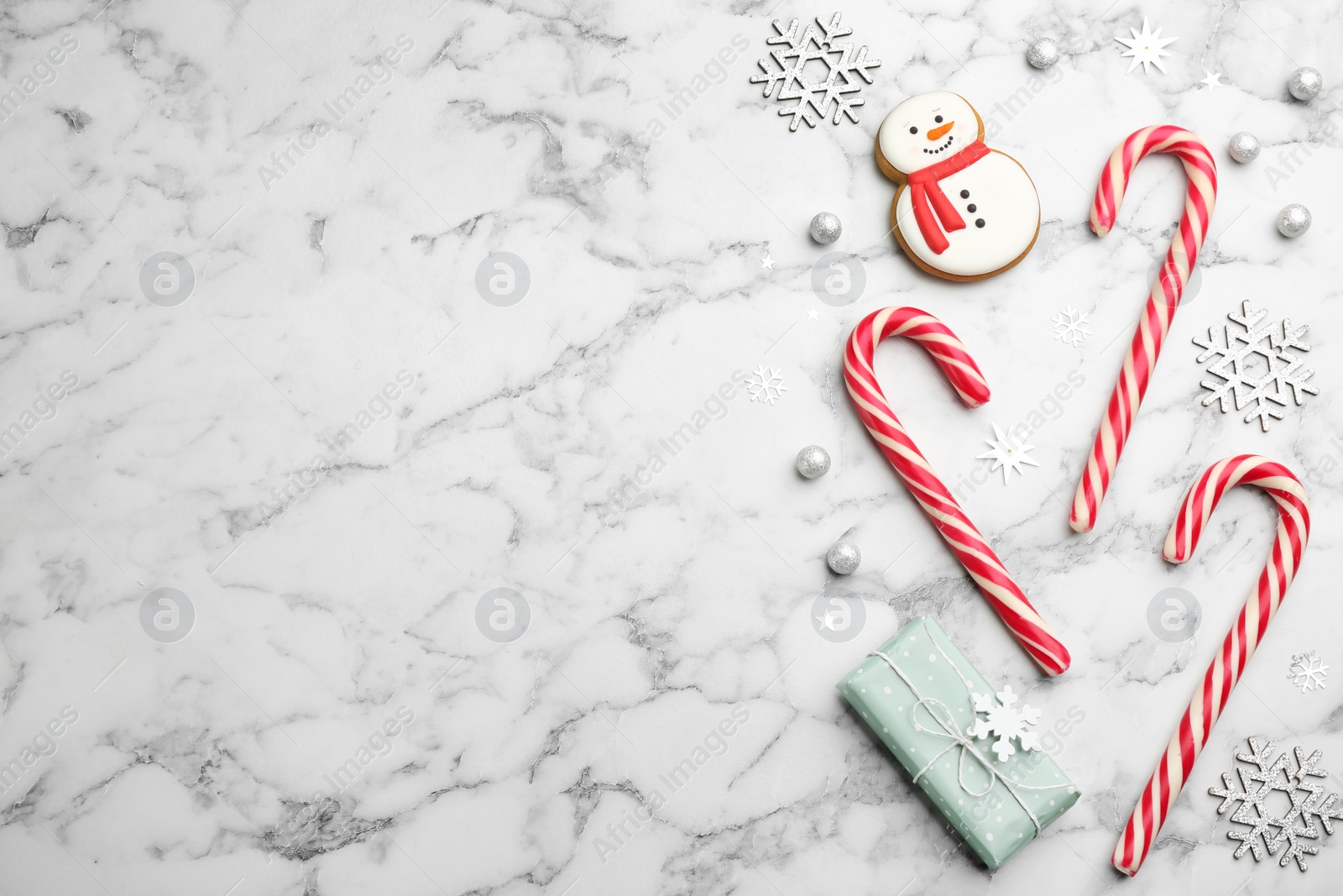 Flat lay composition with candy canes and Christmas decor on white marble table Photo of Flat lay composition with candy canes and Christmas decor on white marble table