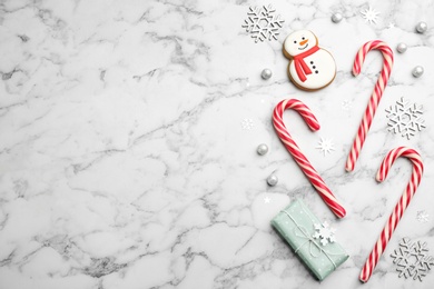 Flat lay composition with candy canes and Christmas decor on white marble table Photo of Flat lay composition with candy canes and Christmas decor on white marble table
