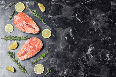 Flat lay composition with fresh raw salmon and rosemary on black marble table, space for text. Fish delicacy Photo of Flat lay composition with fresh raw salmon and rosemary on black marble table, space for text. Fish delicacy
