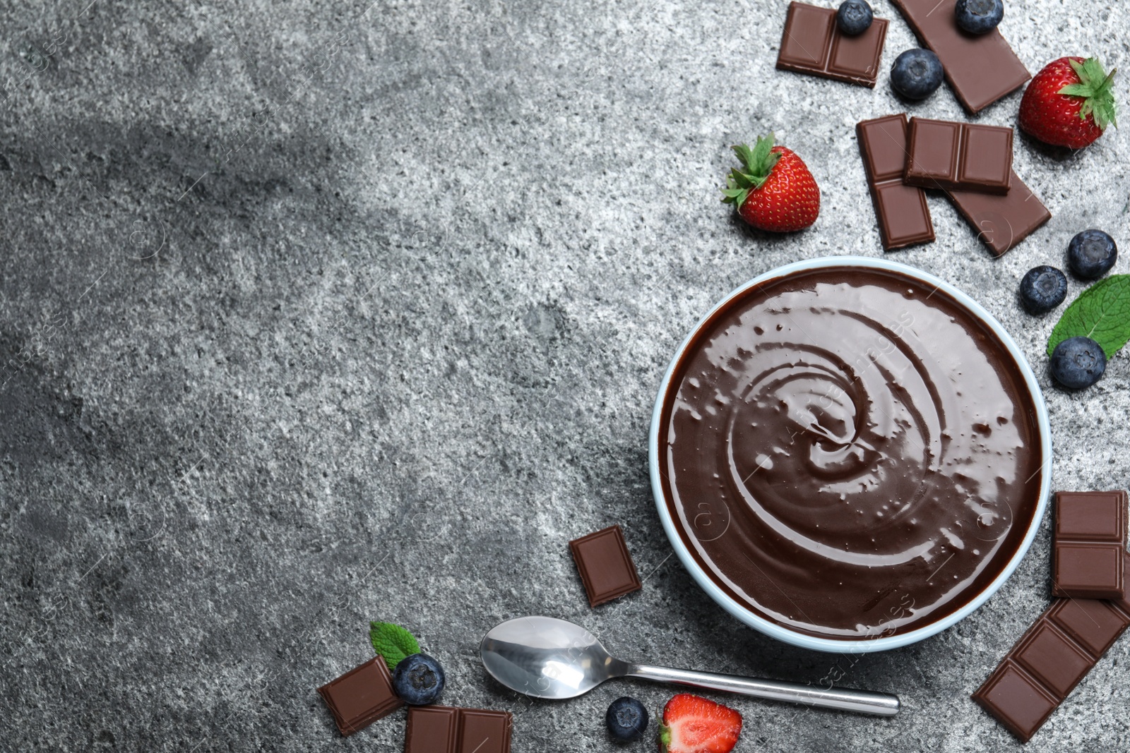 Delicious chocolate cream with berries and mint on grey table, flat lay. Space for text Photo of Delicious chocolate cream with berries and mint on grey table, flat lay. Space for text