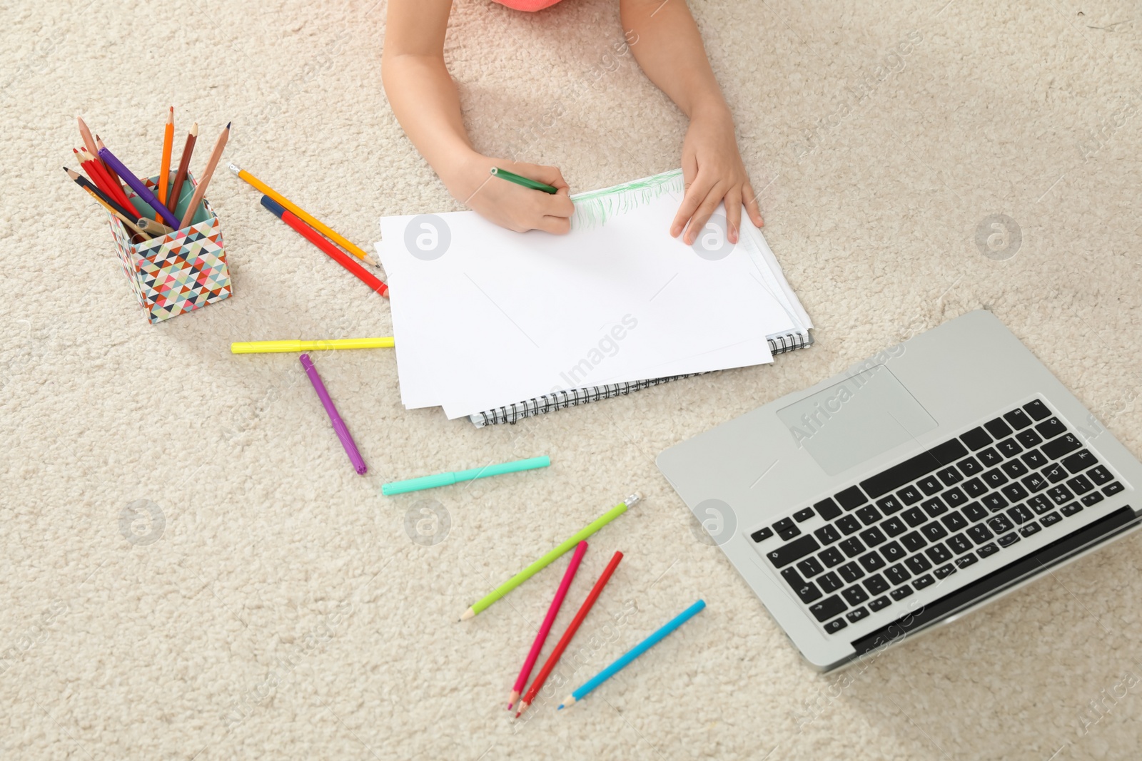 Little girl drawing on paper with pencil at online lesson indoors, closeup. Distance learning Photo of Little girl drawing on paper with pencil at online lesson indoors, closeup. Distance learning