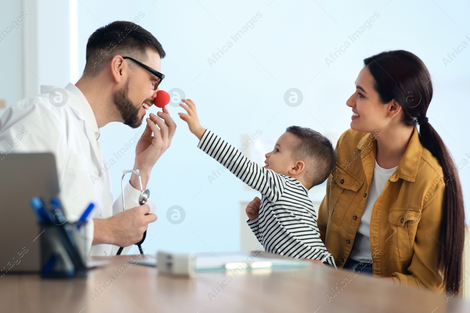 Mother and son visiting pediatrician in hospital. Doctor playing with little boy Photo of Mother and son visiting pediatrician in hospital. Doctor playing with little boy
