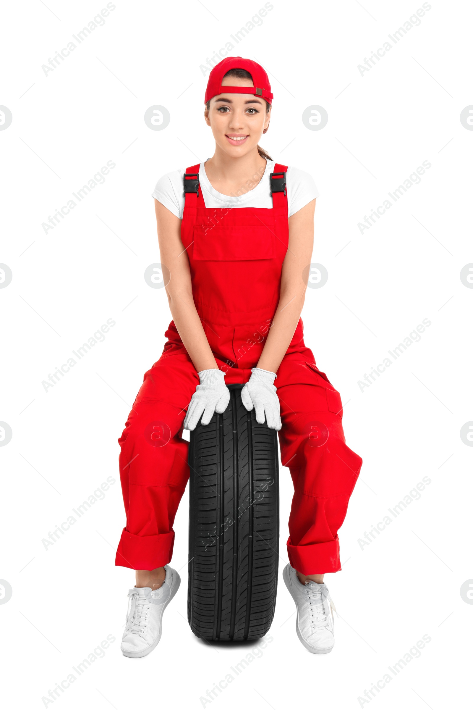 Female mechanic in uniform with car tire on white background Photo of Female mechanic in uniform with car tire on white background