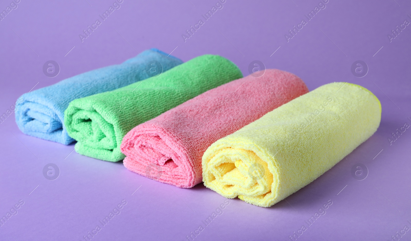 Many colorful microfiber cloths on light background Photo of Many colorful microfiber cloths on light background