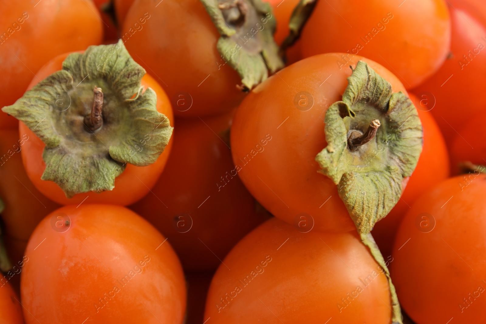 Tasty fresh ripe persimmons as background, closeup Photo of Tasty fresh ripe persimmons as background, closeup