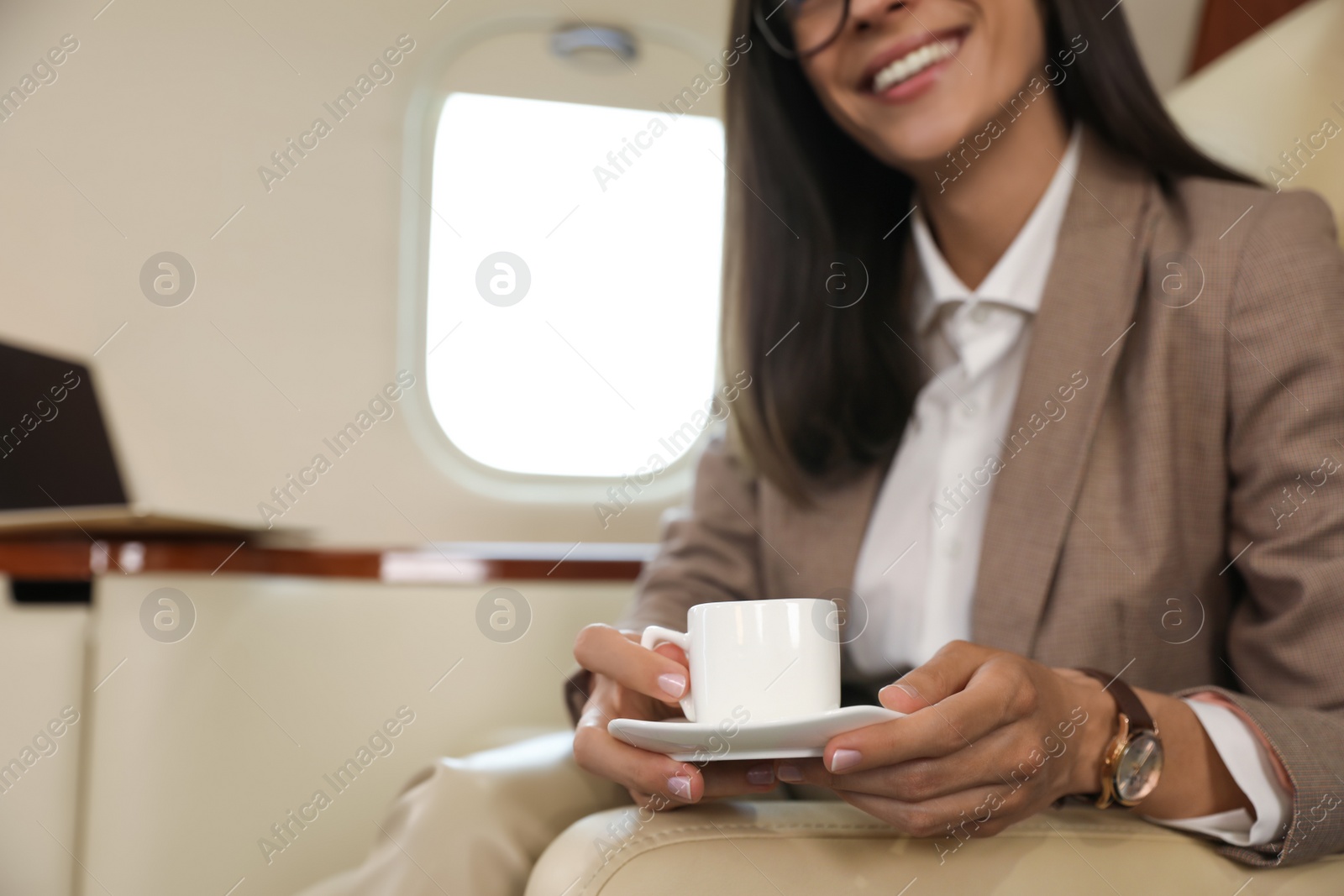 Businesswoman with cup of coffee in airplane during flight, closeup Photo of Businesswoman with cup of coffee in airplane during flight, closeup