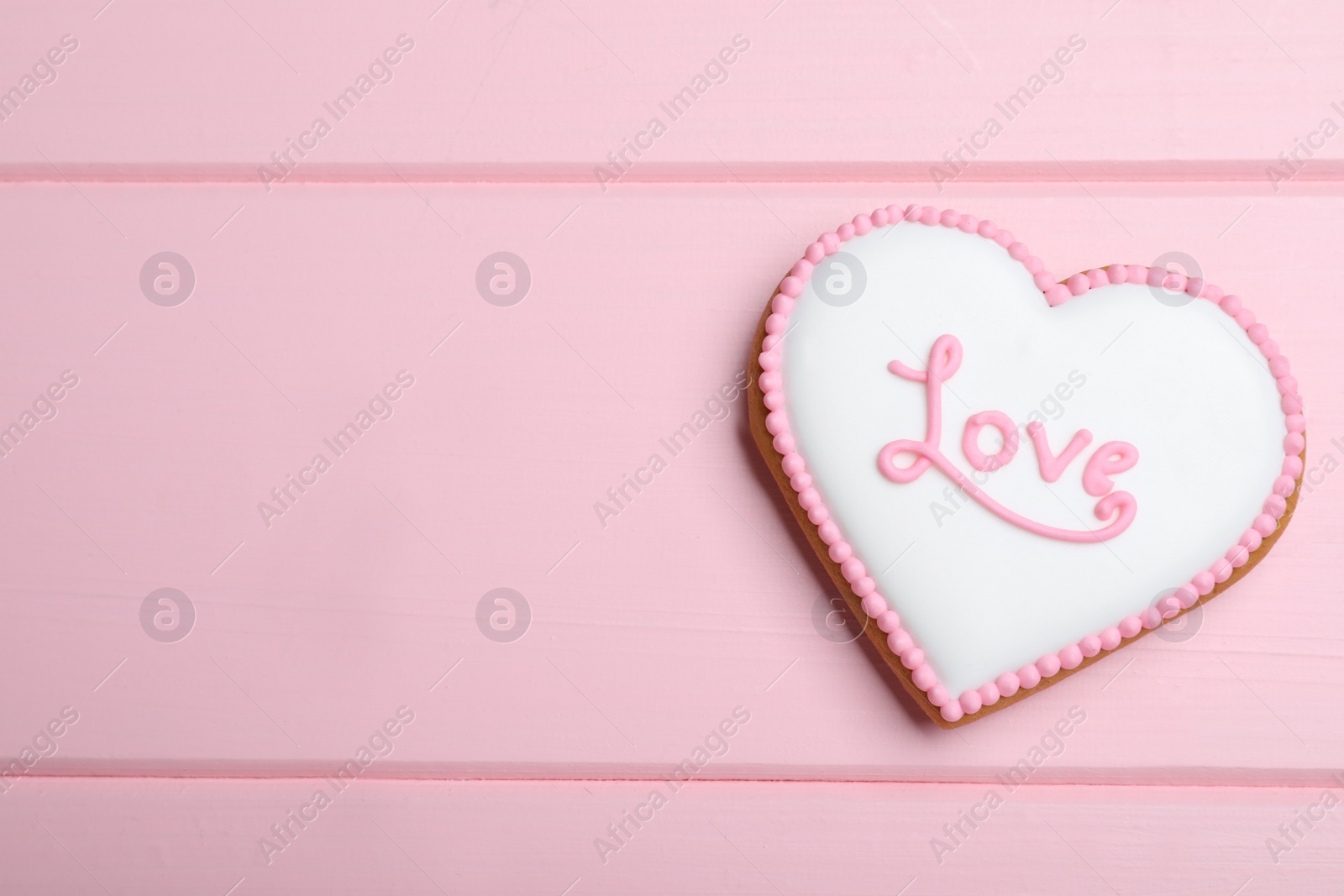 Valentine's day cookie with word Love on pink table, top view. Space for text Photo of Valentine's day cookie with word Love on pink table, top view. Space for text