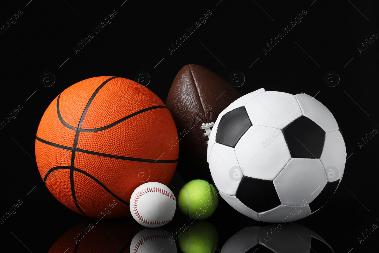 Set of different sport balls on black mirror surface Photo of Set of different sport balls on black mirror surface