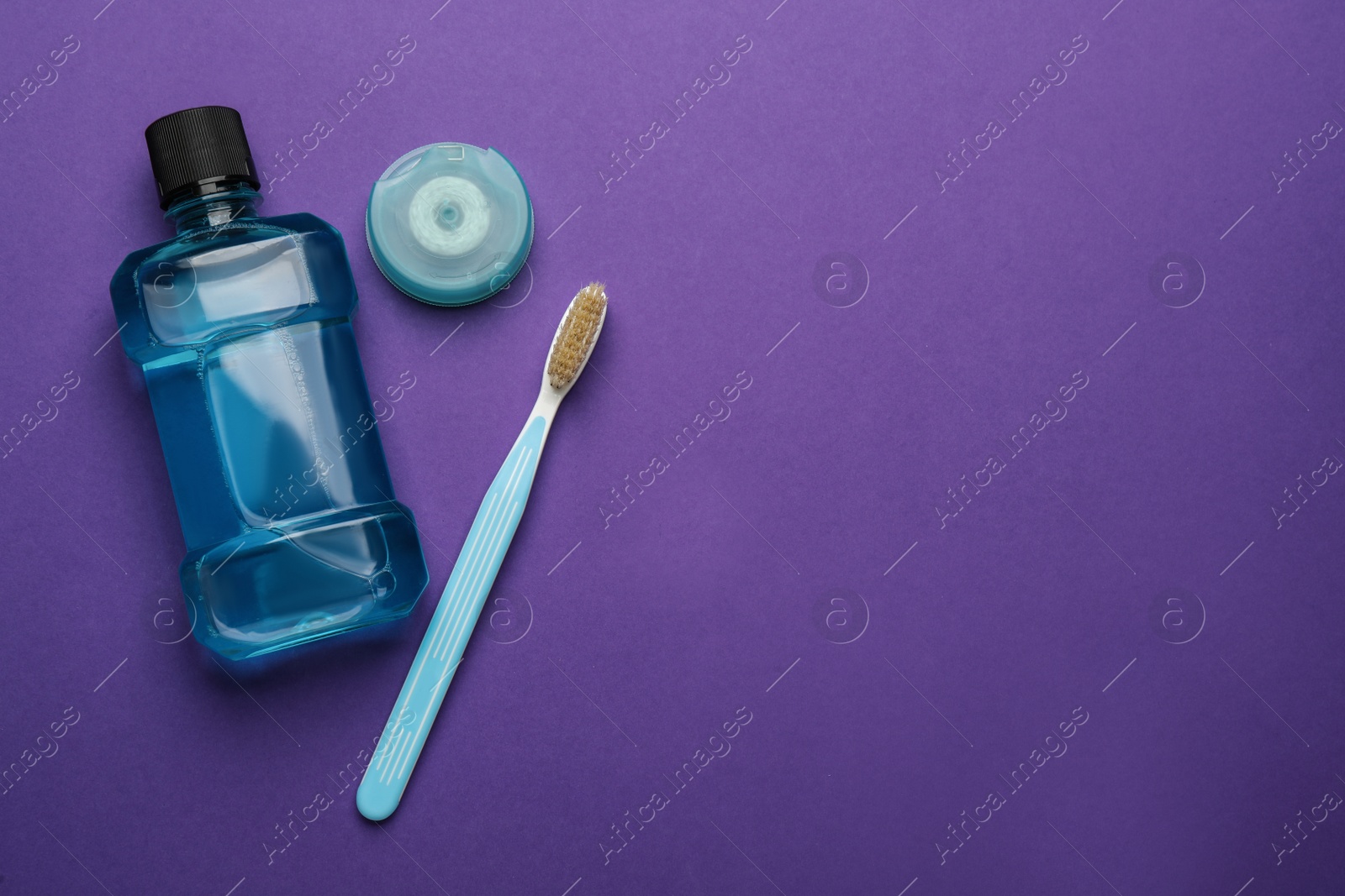 Mouthwash, toothbrush and dental floss on purple background, flat lay. Space for text Photo of Mouthwash, toothbrush and dental floss on purple background, flat lay. Space for text