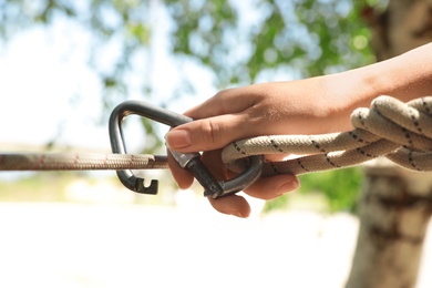 Woman using screw lock carabiner during training outdoors, closeup Photo of Woman using screw lock carabiner during training outdoors, closeup