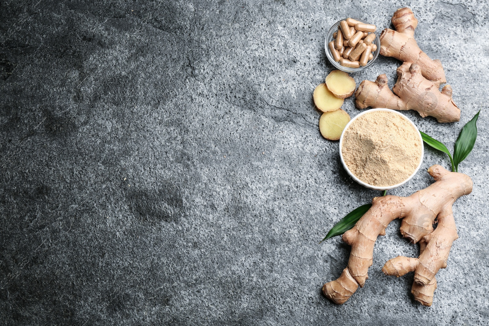 Dry, fresh and capsuled ginger on grey table, flat lay. Space for text Photo of Dry, fresh and capsuled ginger on grey table, flat lay. Space for text