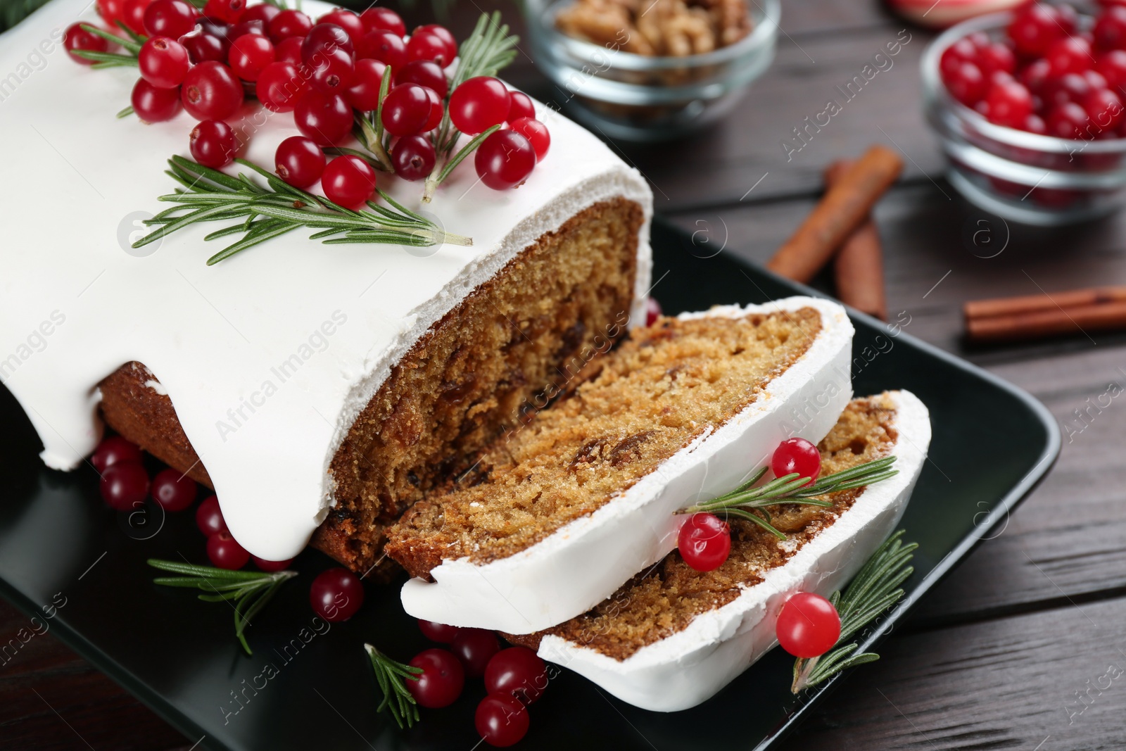 Photo of Traditional classic Christmas cake decorated with cranberries and rosemary on wooden table, closeup