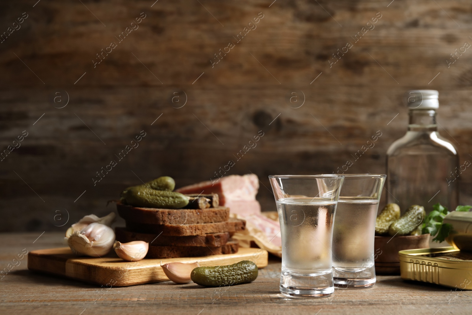 Cold Russian vodka with snacks on wooden table Photo of Cold Russian vodka with snacks on wooden table