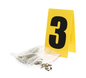 Plastic bag with cannabis and crime scene marker with number three isolated on white. Photo of Plastic bag with cannabis and crime scene marker with number three isolated on white.