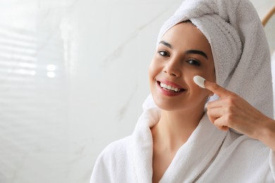 Woman using silkworm cocoon in skin care routine at home. Space for text Photo of Woman using silkworm cocoon in skin care routine at home. Space for text