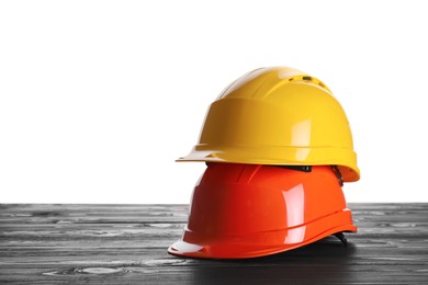 Different hard hats on wooden table against white background. Space for text Photo of Different hard hats on wooden table against white background. Space for text