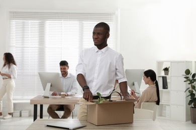 New coworker unpacking box with personal items at workplace in office Photo of New coworker unpacking box with personal items at workplace in office