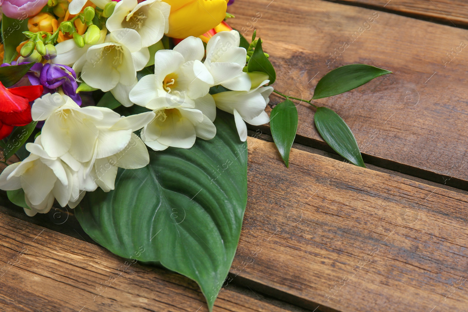 Beautiful freesia bouquet on wooden background Photo of Beautiful freesia bouquet on wooden background