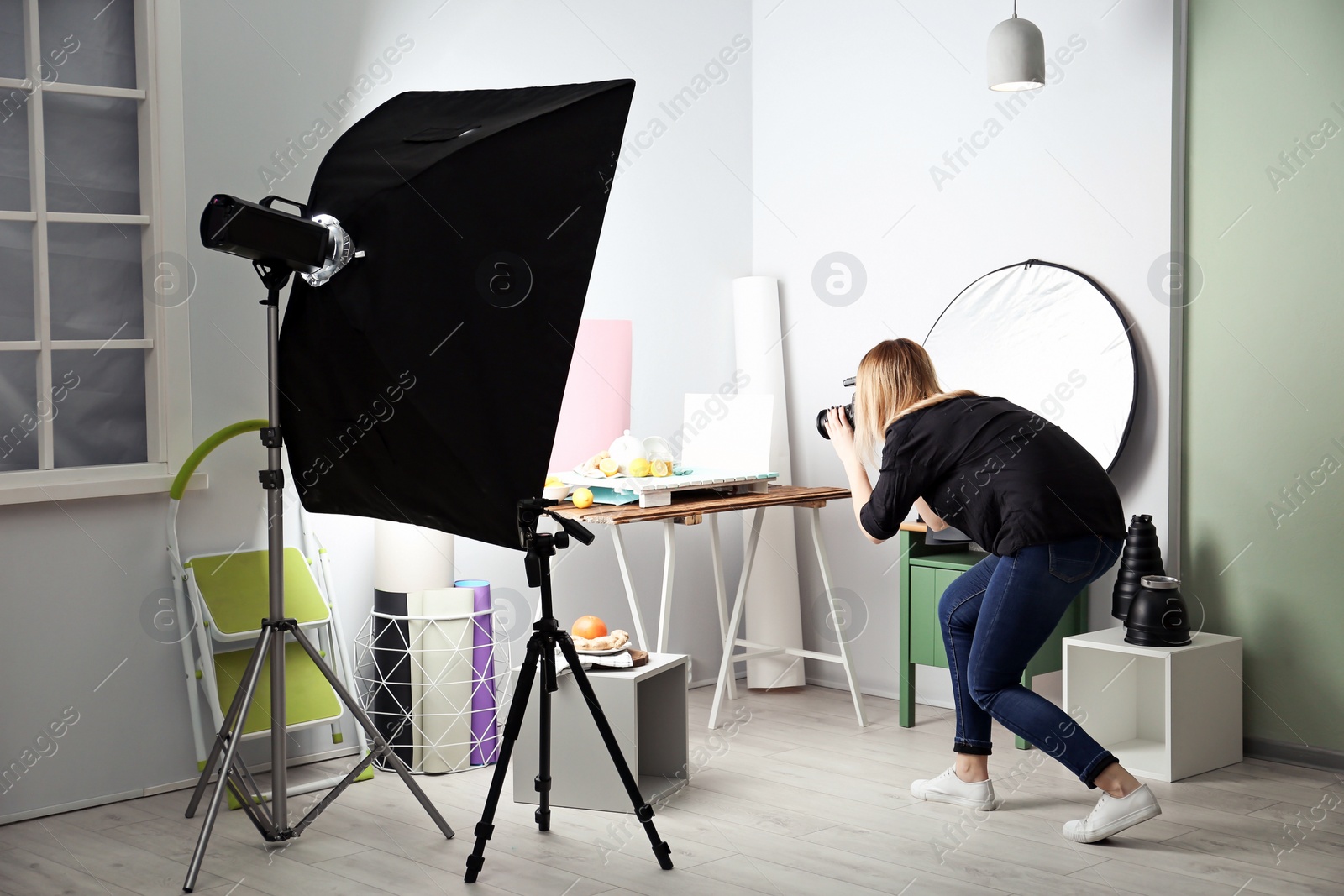 Woman taking photo of food with professional camera in studio Photo of Woman taking photo of food with professional camera in studio