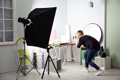 Woman taking photo of food with professional camera in studio Photo of Woman taking photo of food with professional camera in studio