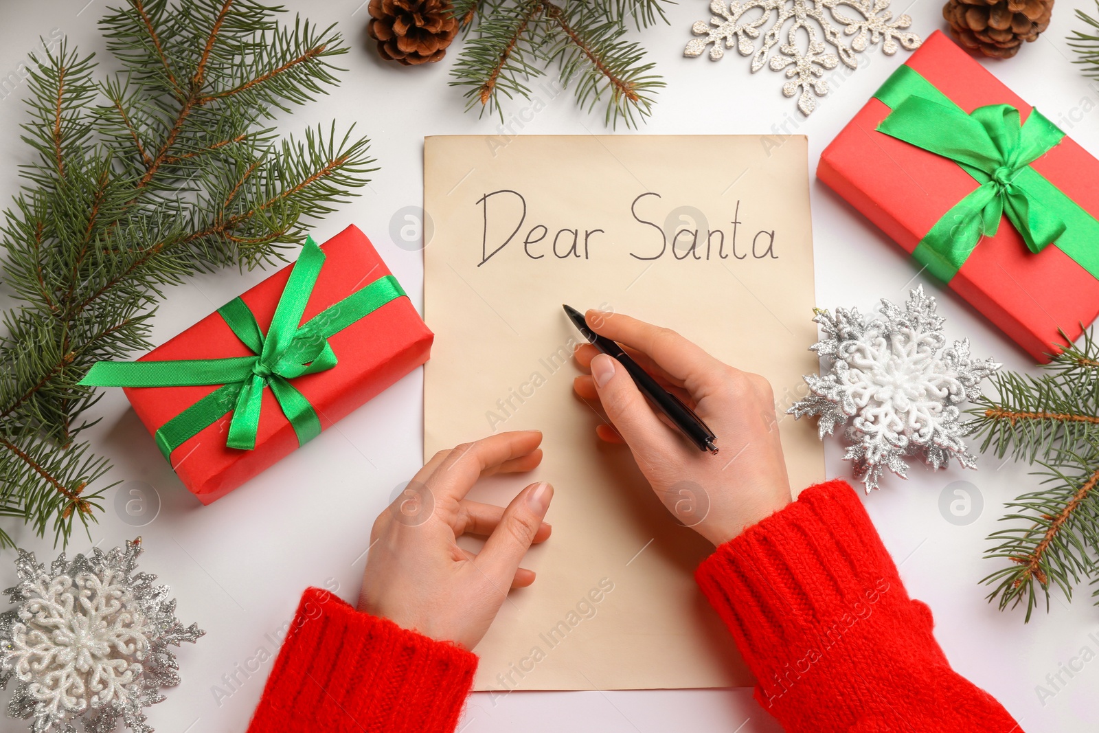 Top view of woman writing letter to Santa at white table, closeup Photo of Top view of woman writing letter to Santa at white table, closeup