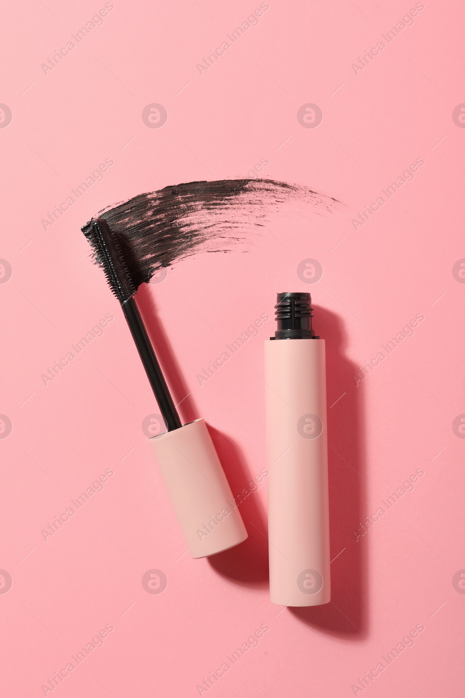 Mascara for eyelashes and smear on pink background, flat lay. Makeup product Photo of Mascara for eyelashes and smear on pink background, flat lay. Makeup product